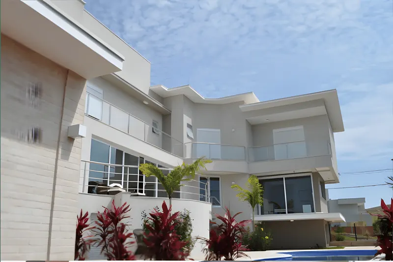 Fachada de residência contemporânea com esquadrias e guarda-corpos de vidro